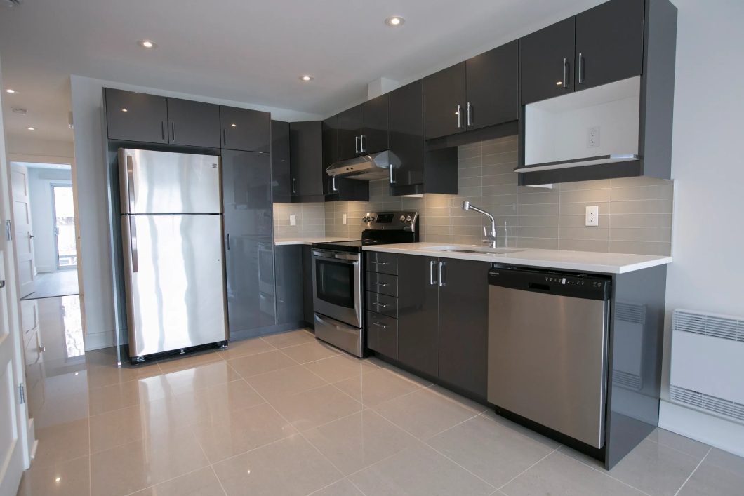 Interior of a modern compact white kitchen with gas stove, oven, refrigerator